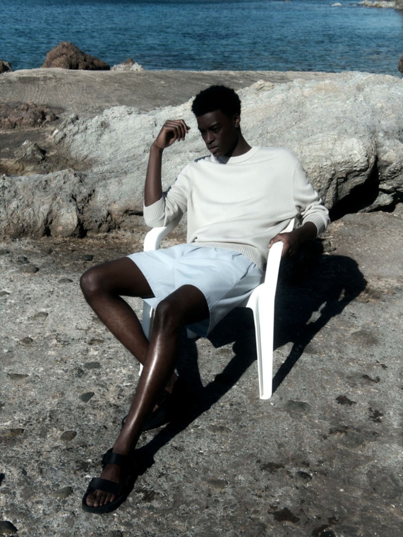 Relaxing, Babacar N'doye sports a COS relaxed-fit jumper with drawstring shorts and leather sandals.