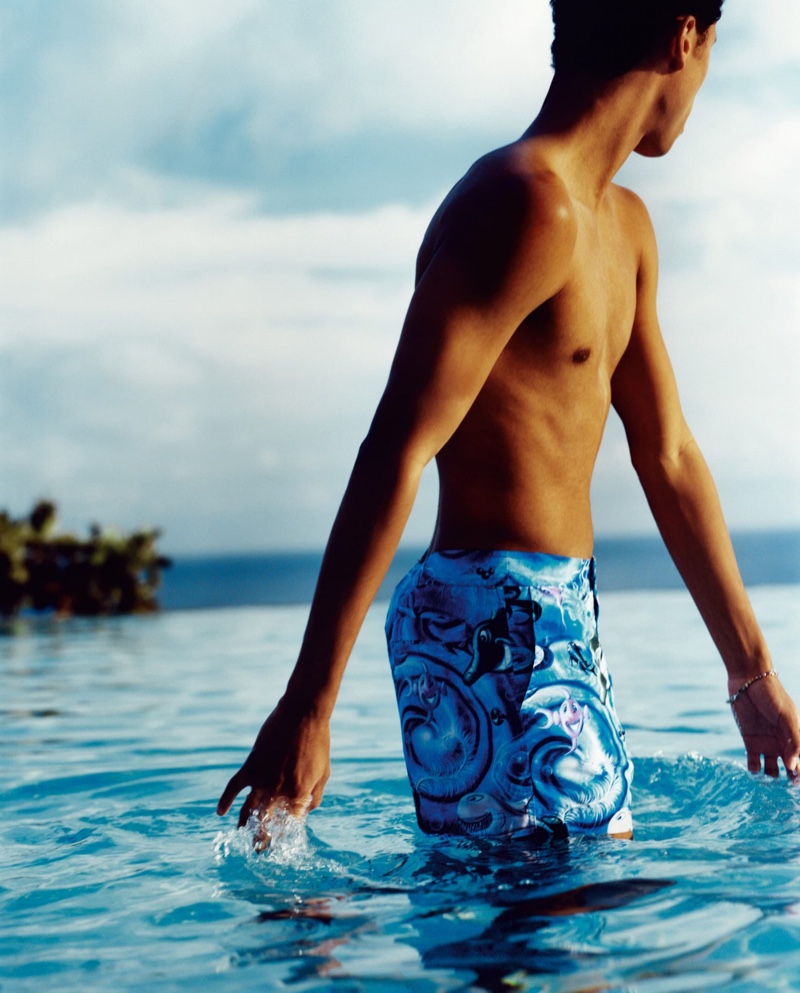 Taking a dip, Jecardi Sykes dons Dior Men swim shorts that feature a Kenny Scharf print.