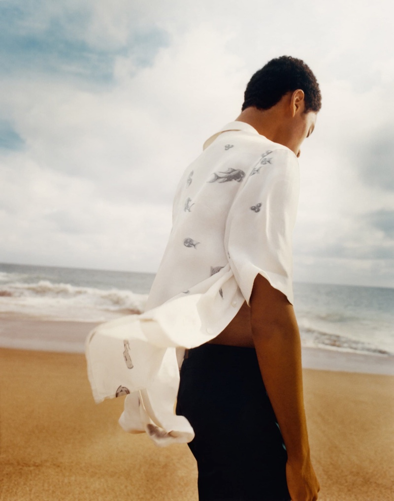 Hitting the beach, Jecardi Sykes sports a printed shirt from Dior Men's 2021 beachwear capsule collection.