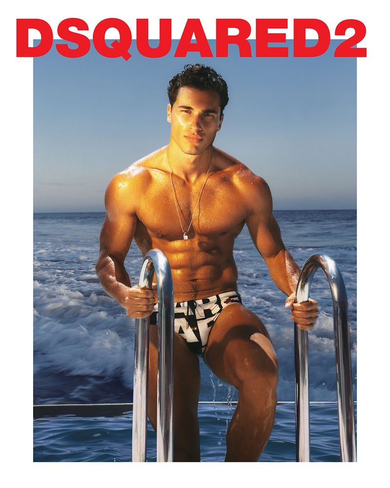 Sporting a logo print swimsuit, Dean Perona fronts Dsquared2's 2021 beachwear campaign.