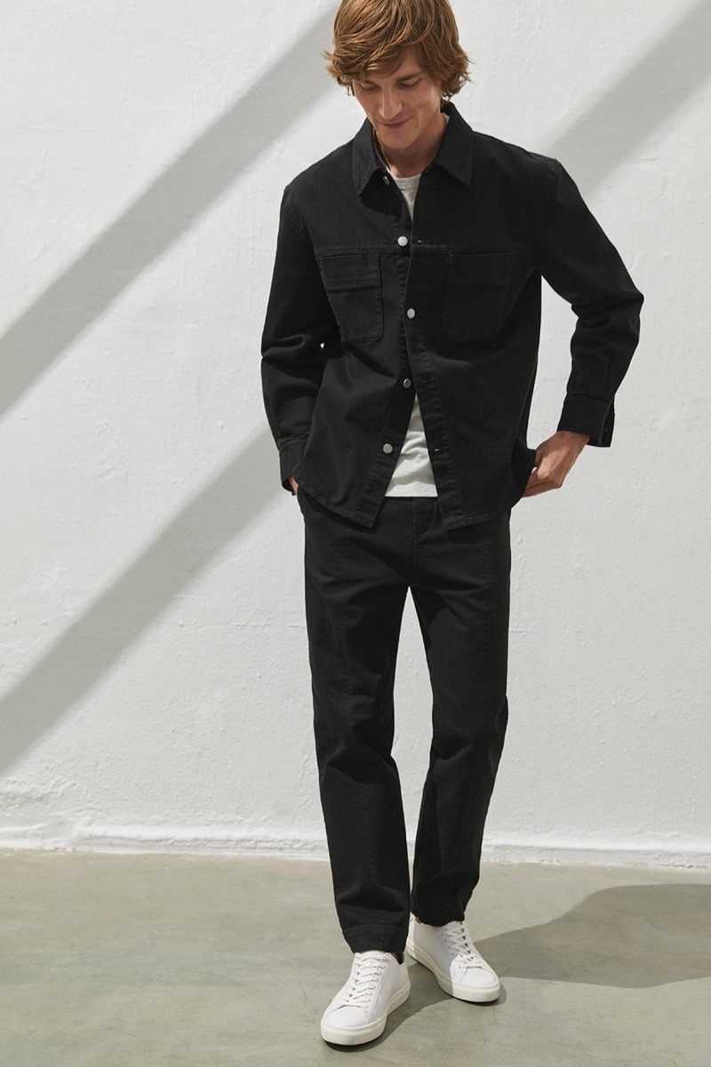 All smiles, Charlie Westerberg models a black denim jacket with pants from Filippa K.