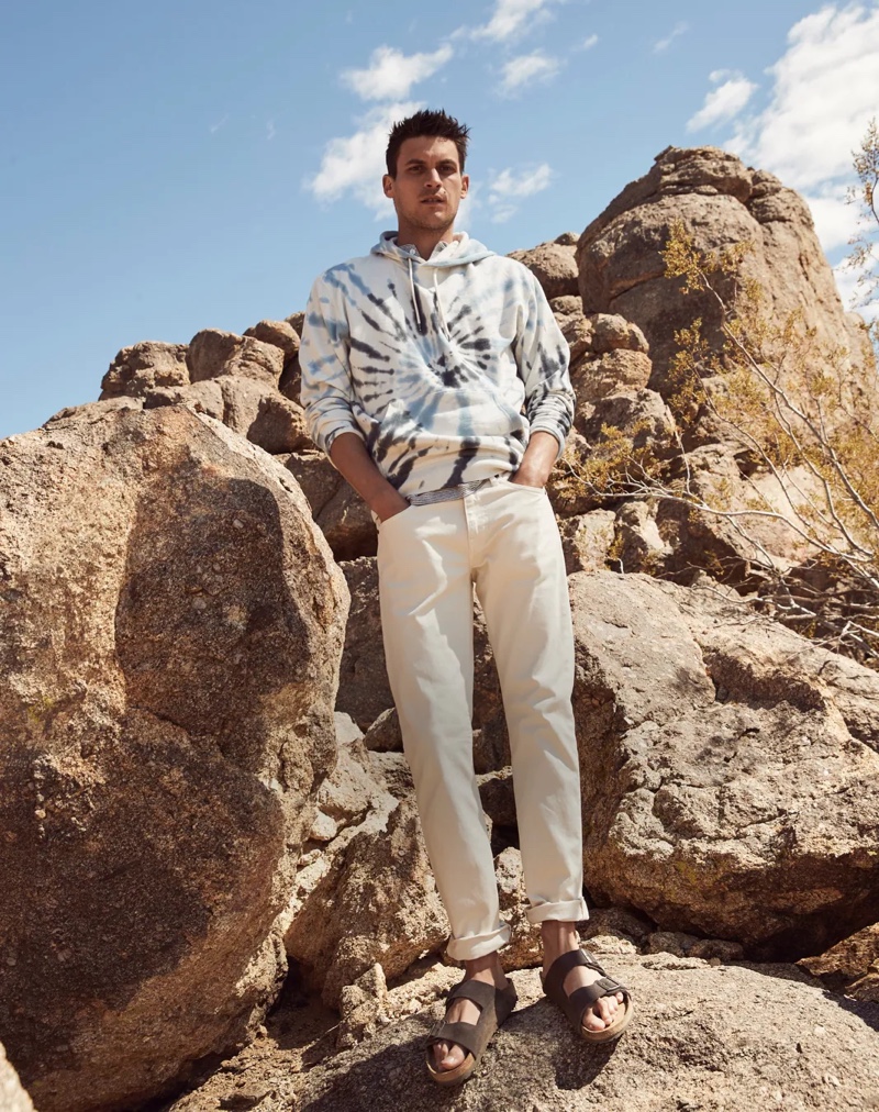 Embracing the tie-dye trend, Miles Garber sports a J.Crew tie-dye hoodie with 484 slim-fit, five-pocket pants, and Birkenstock sandals.