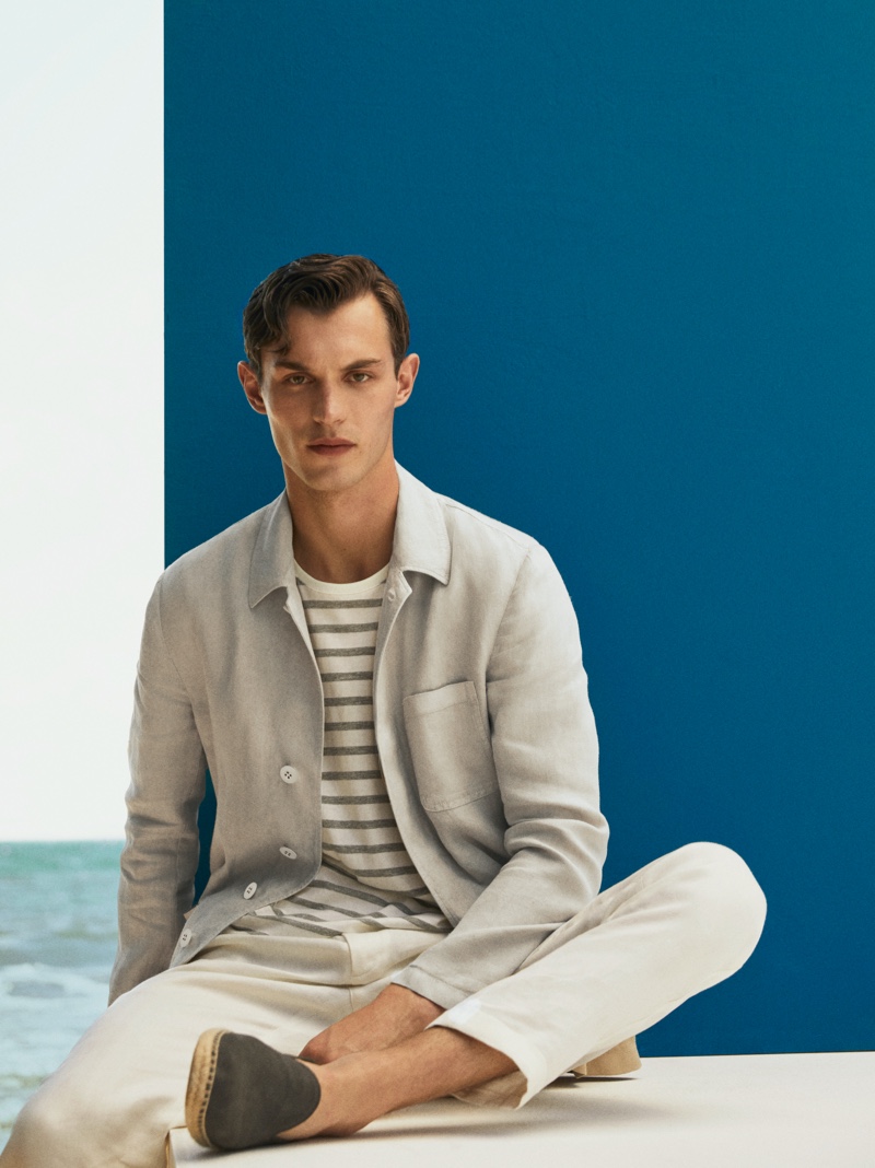 Front and center, Kit Butler models a Massimo Dutti slim-fit linen dyed overshirt with a striped cotton t-shirt, 100% linen casual fit trousers, and blue split suede leather espadrilles.