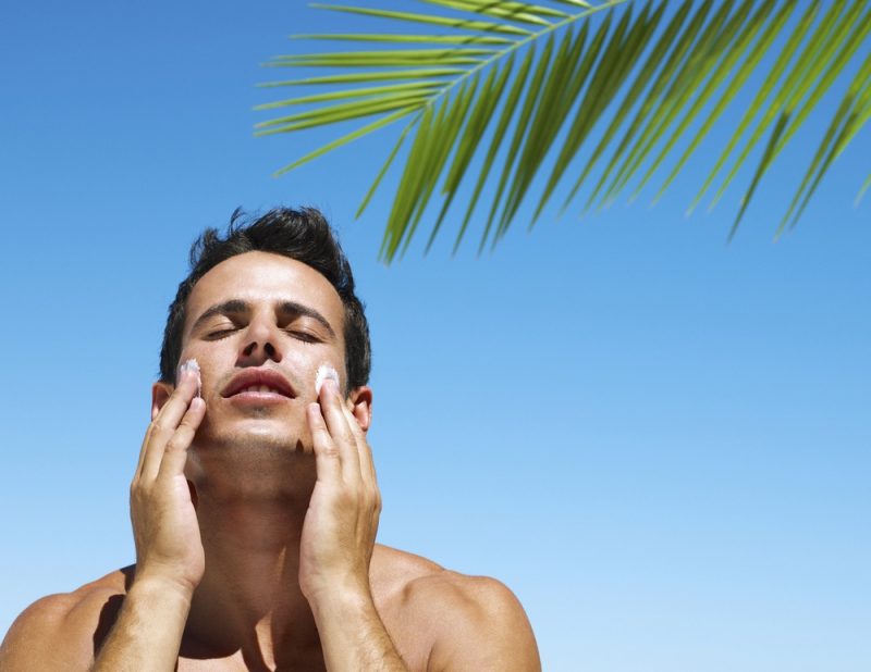 Man Putting Sun Skin Protection In Summer on beach