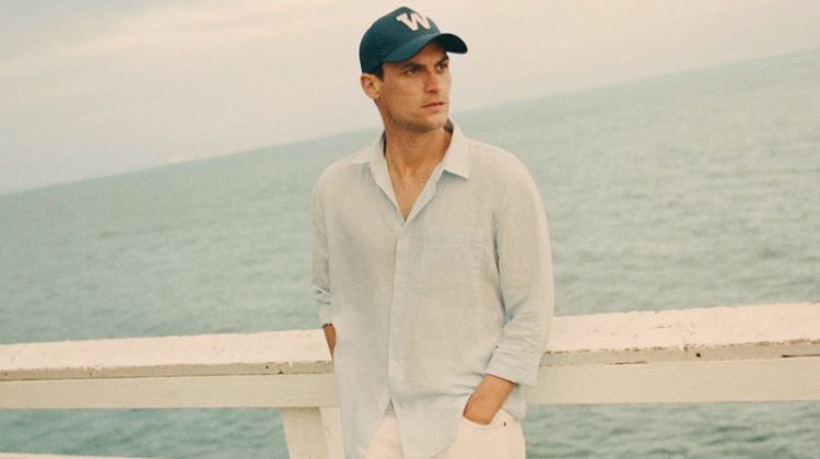 Donning sleek summer style, Miles Garber wears a linen shirt and white pants from Zara.