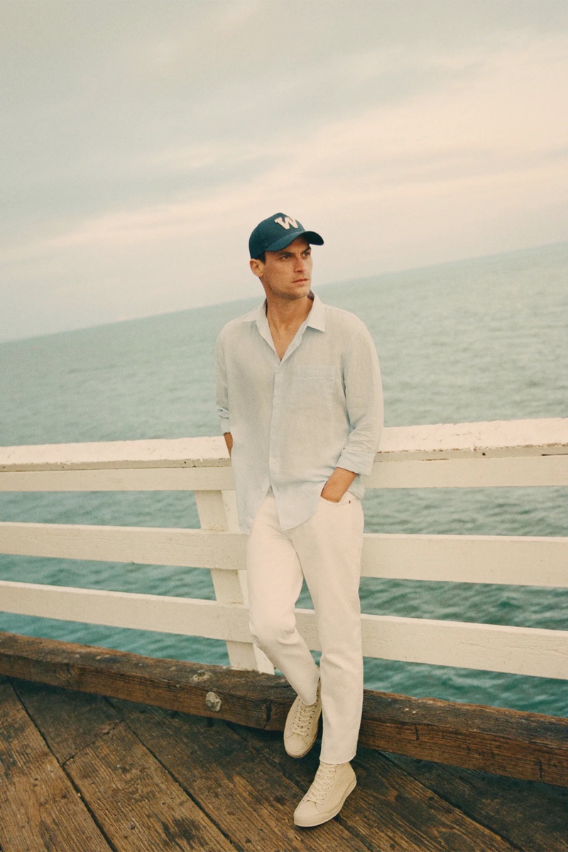 Donning sleek summer style, Miles Garber wears a linen shirt and white pants from Zara.