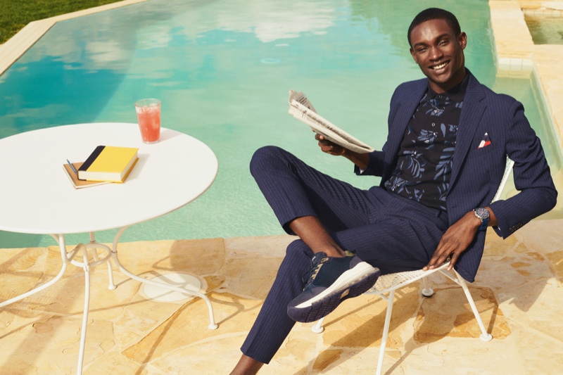 Relaxing poolside, Victor Ndigwe embraces tailoring in a sharp Tommy Hilfiger suit.