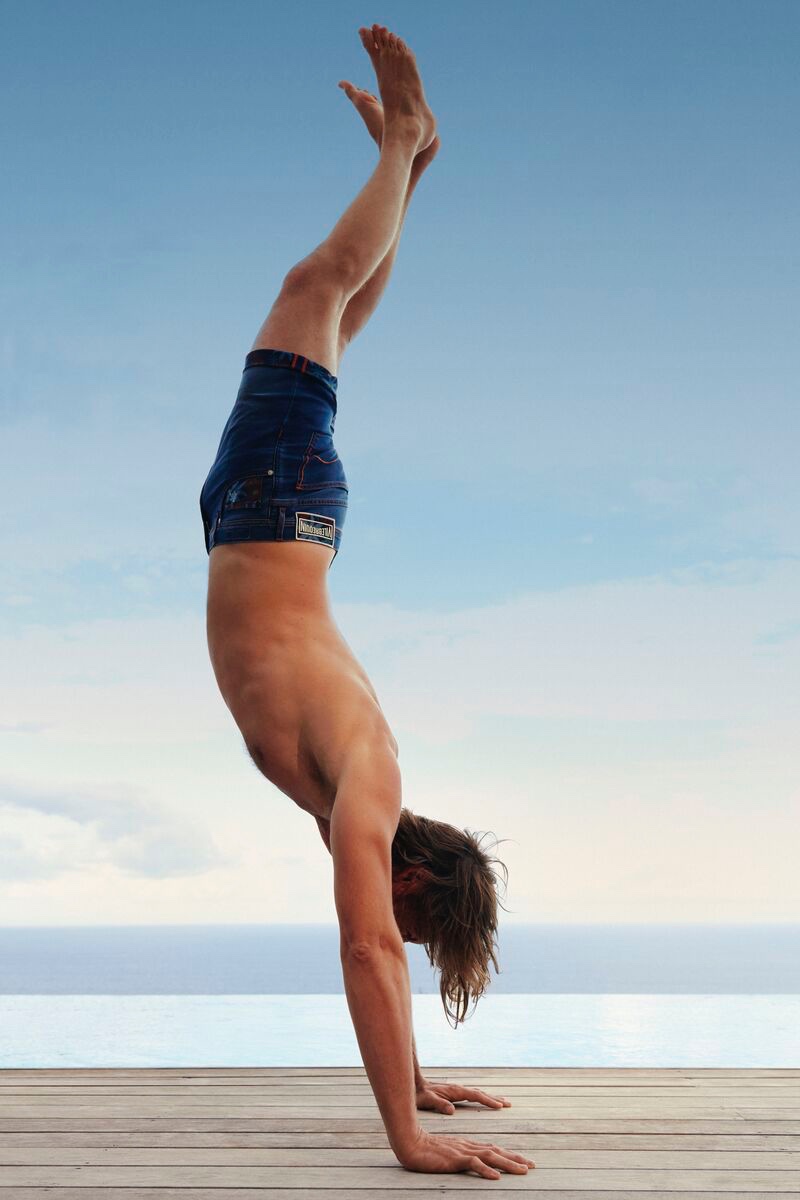 Doing a handstand, James Crabtree rocks Vilebrequin's flat belt swim trunks.