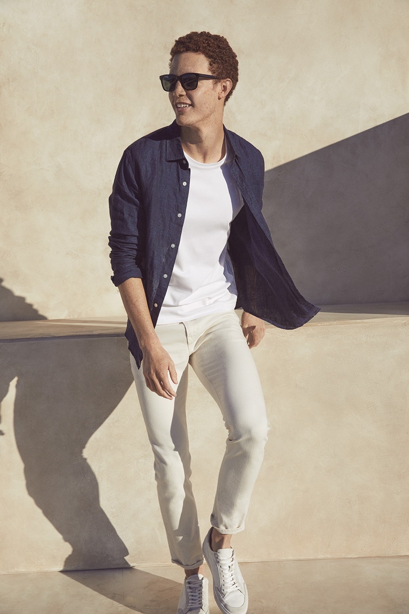 Cool in shades, Dustin Shirley rocks an open button-down shirt with a tee and off-white jeans from Banana Republic.