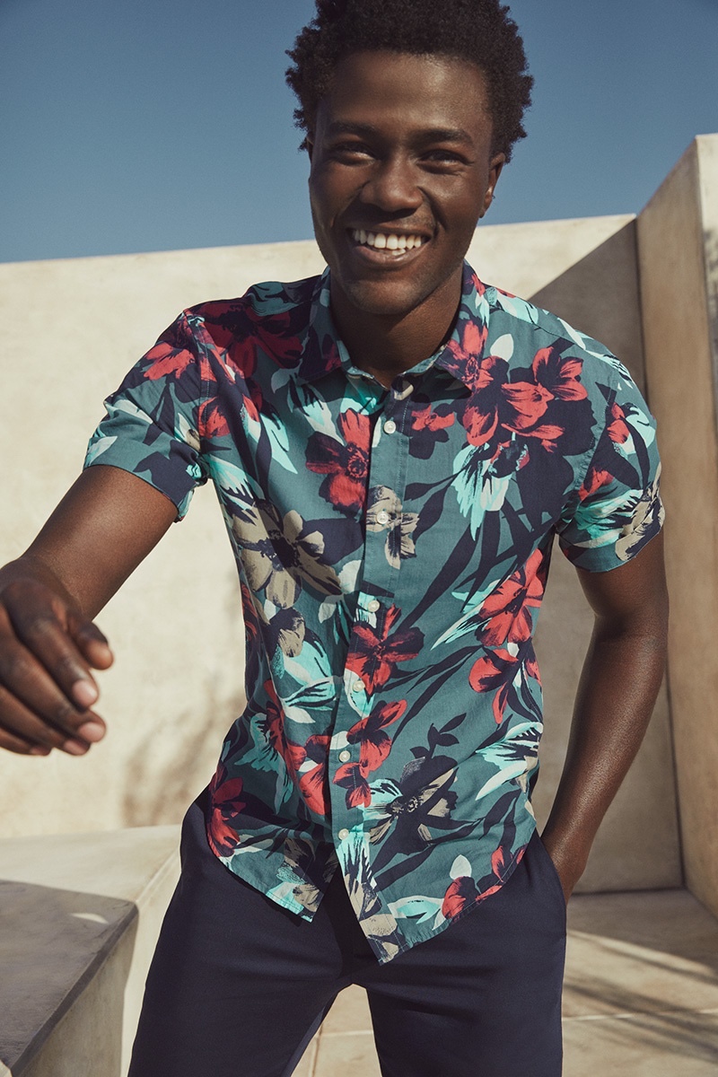 Cheesing ear to ear, Remi Chester spreads joy in a tropical print short-sleeve shirt from Banana Republic.