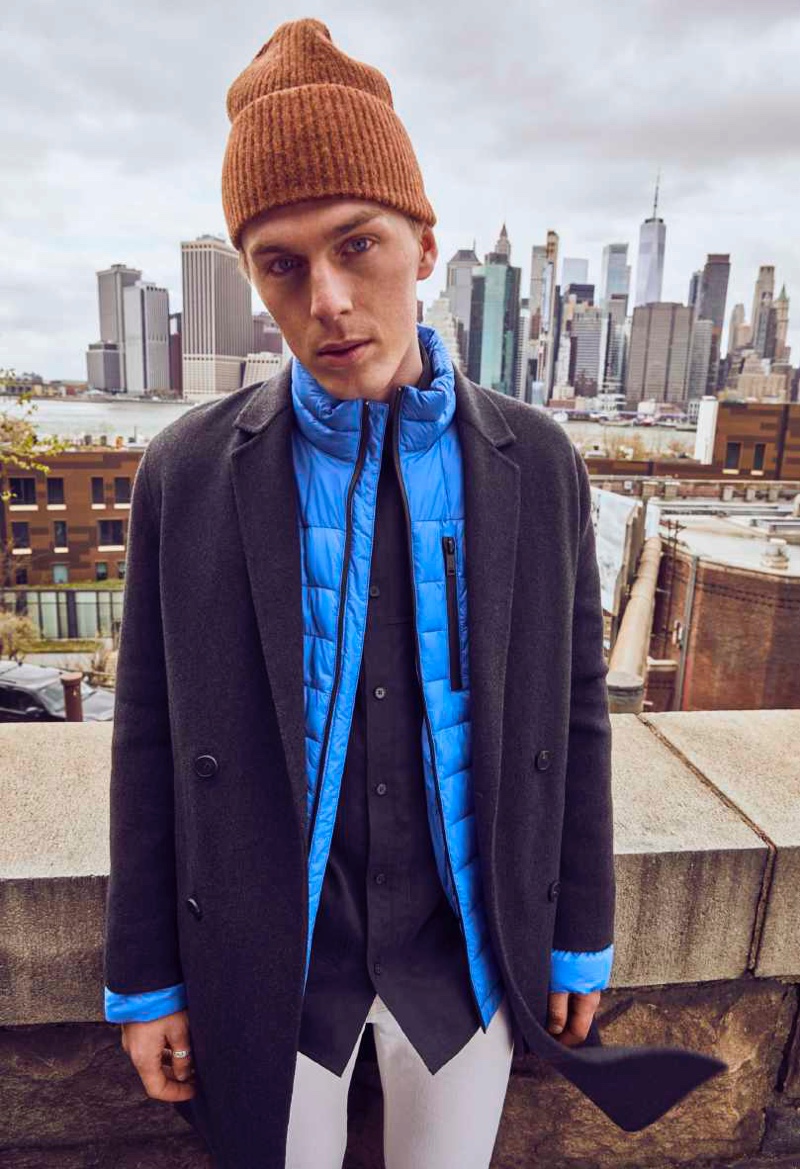 Pero Simic dons a double-breasted coat with a blue puffer jacket from DKNY's fall-winter 2021 men's collection.