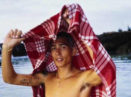 Taking to the beach, Evan Mock wears his RVCA Palaka plaid board shorts and covers up in a matching blanket.