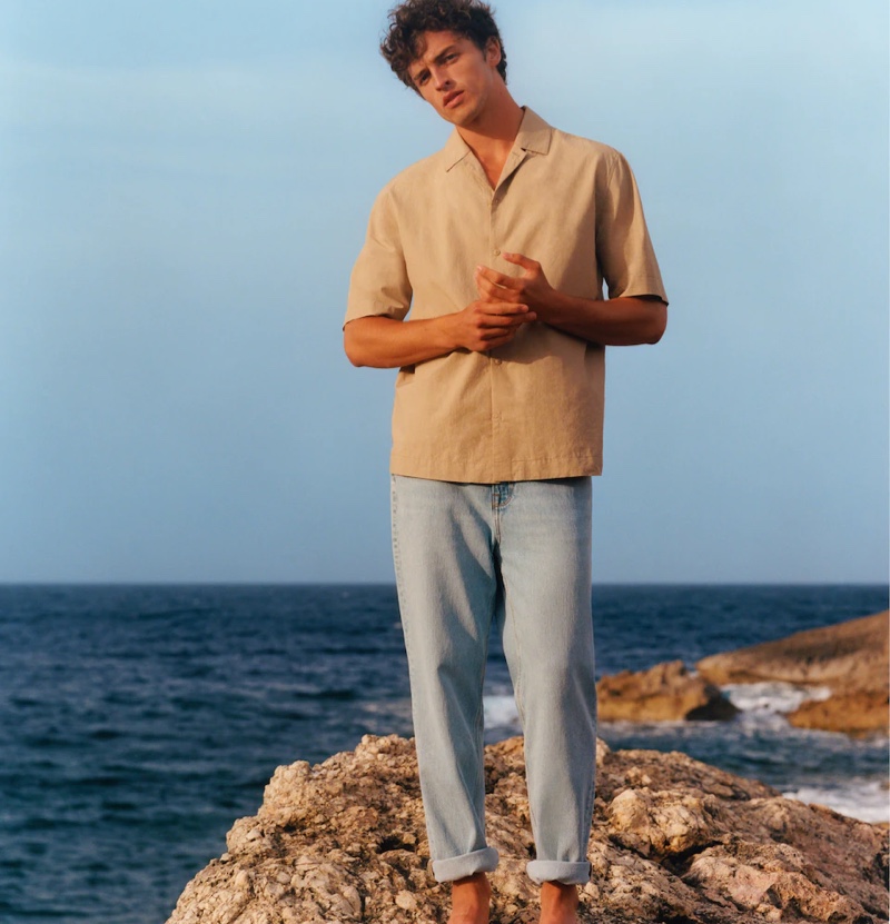 Alberto Perazzolo wears a Cuban-collared shirt with light wash jeans from Mango Man's summer 2021 collection.