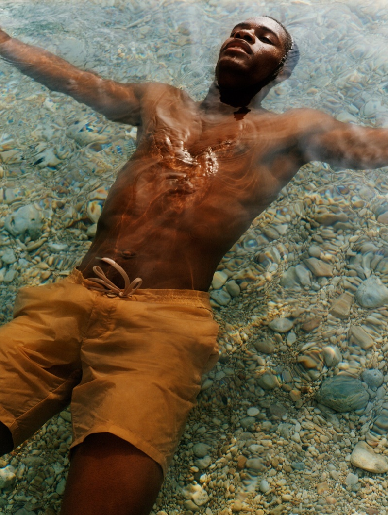 Taking a dip, Mukasa Kakonge models swim shorts from Mango Man's summer 2021 collection.