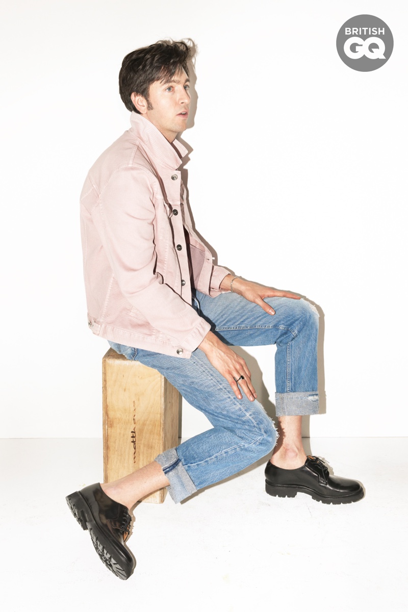 Hitting the photo studio, Nicholas Braun wears a Brunello Cucinelli jacket with Levi's jeans and Grenson shoes. The American actor also dons a ring by Miansai.