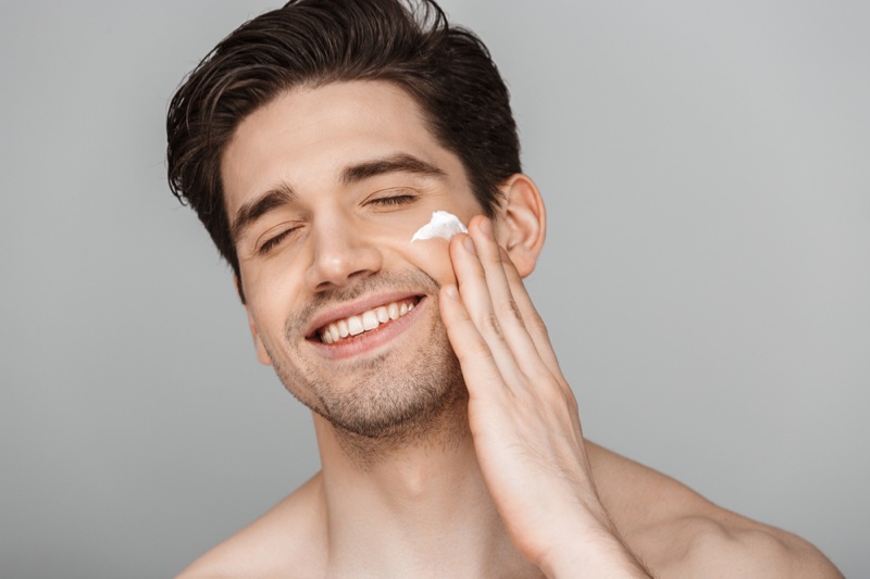 Smiling Male Model Applying Face Cream Skincare