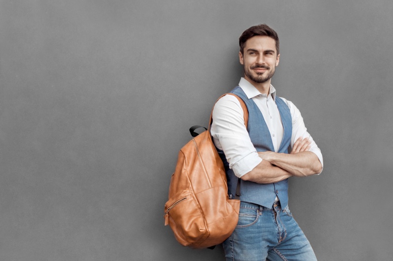 Smiling Man Vest Brown Backpack Jeans