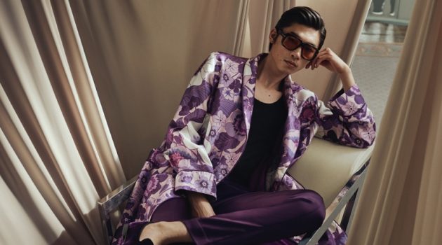 Relaxing, Hidetatsu Takeuchi wears a Tom Ford piped floral-print silk-twill robe with purple leather-trimmed velvet loafers and brown round-frame tortoiseshell acetate sunglasses.