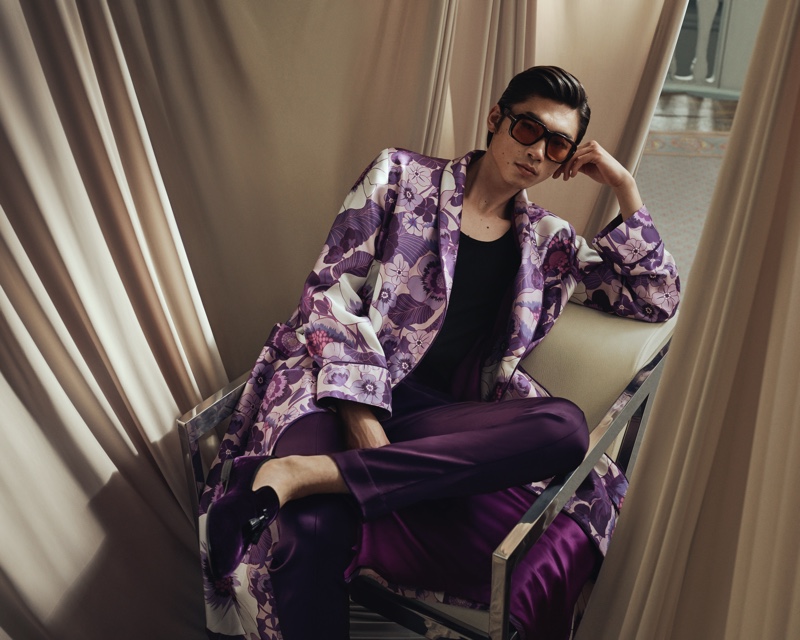 Relaxing, Hidetatsu Takeuchi wears a Tom Ford piped floral-print silk-twill robe with purple leather-trimmed velvet loafers and brown round-frame tortoiseshell acetate sunglasses.