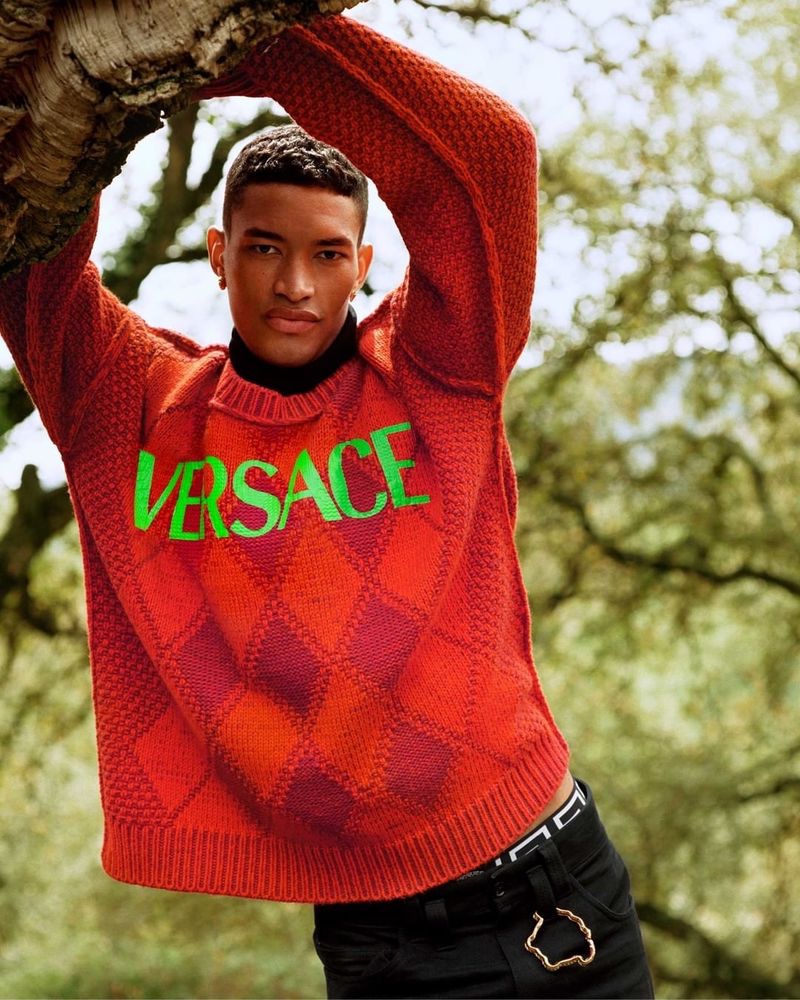 Raphael Balzer dons a logo-adorned argyle sweater for Versace's pre-fall 2021 men's campaign.