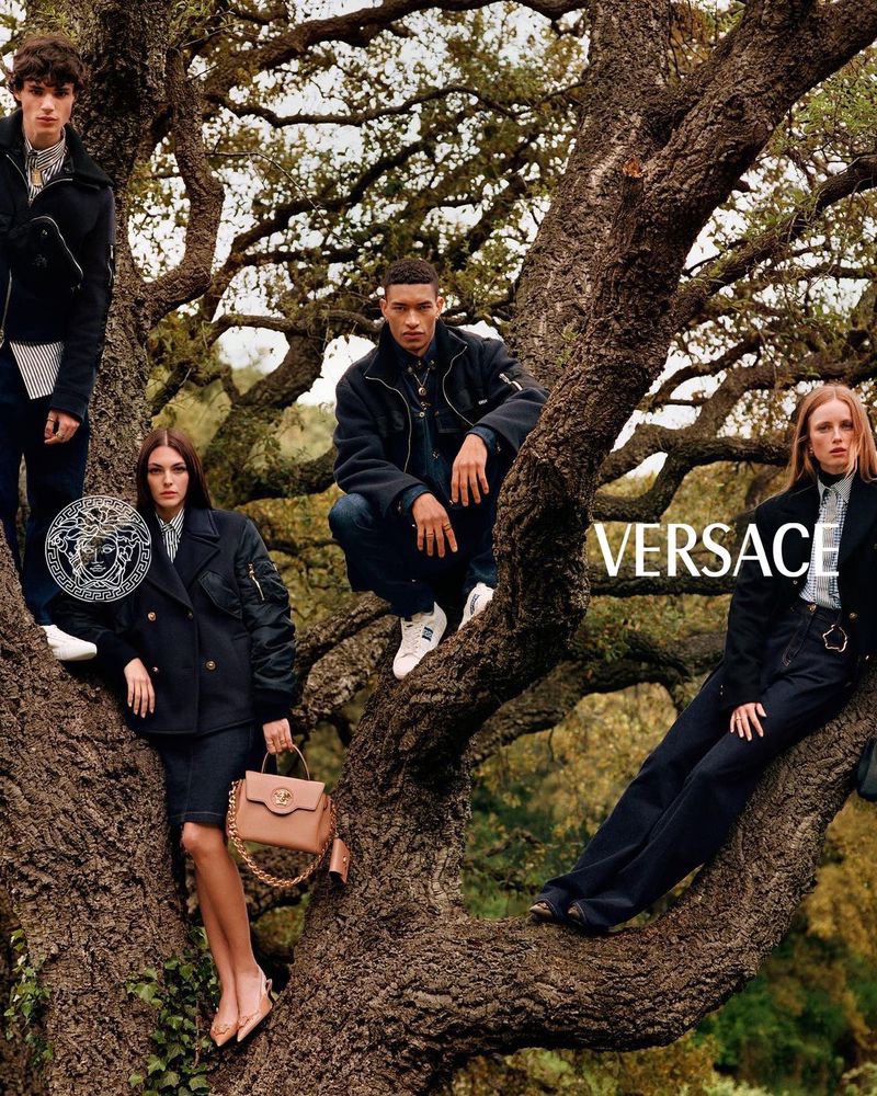 Posing in a large tree, models Fernando Lindez, Vittoria Ceretti, Raphael Balzer, and Rianne Van Rompaey come together for Versace's pre-fall 2021 campaign.