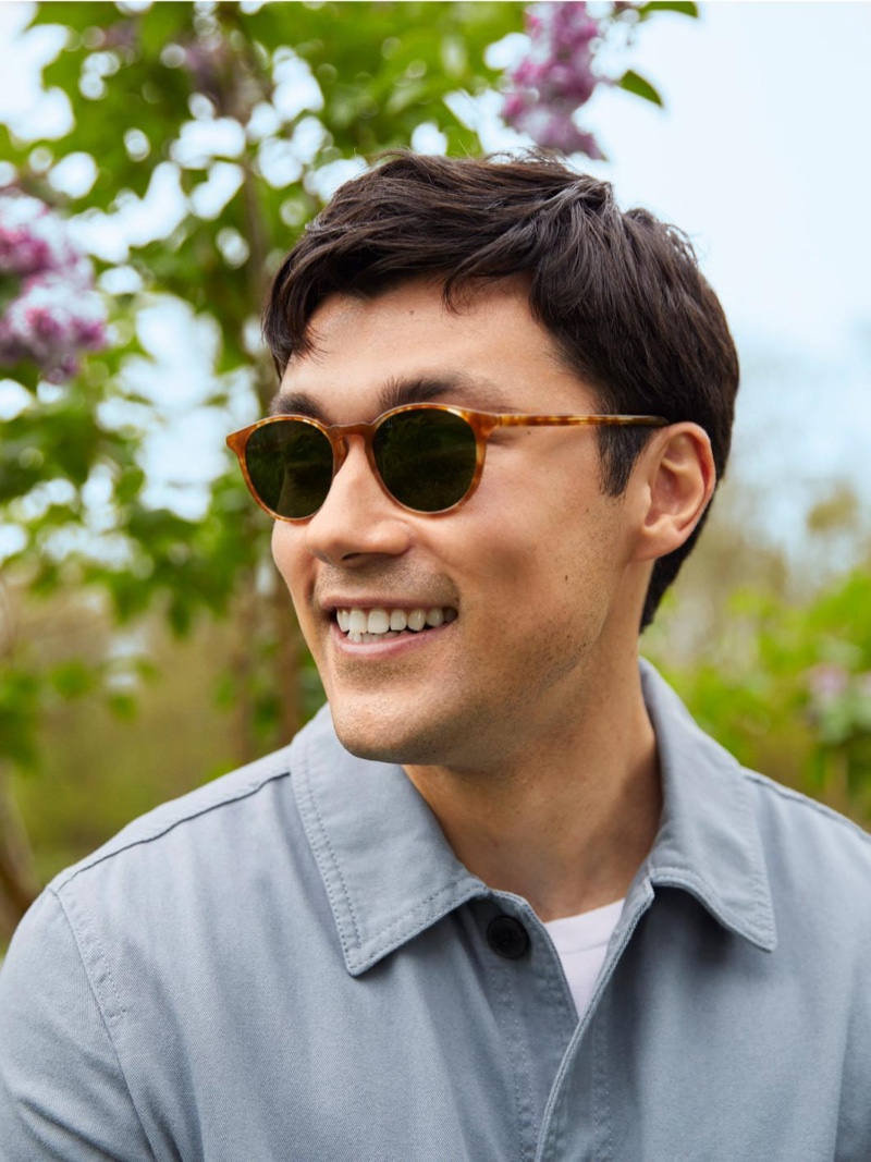 All smiles, Ruslan Aliiev models Warby Parker's Butler sunglasses in Butterscotch Tortoise.