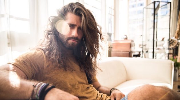 Top 10 Tips to Take Care of Your Hair in the Summer Man Long Hair Sitting Couch Sun Summer