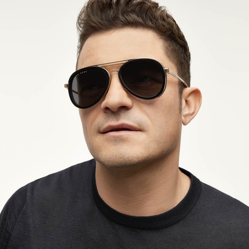 Looking to stand out from the crowd, Orlando Bloom wears BOSS's triple-bridge sunglasses with black and gold-tone frames.