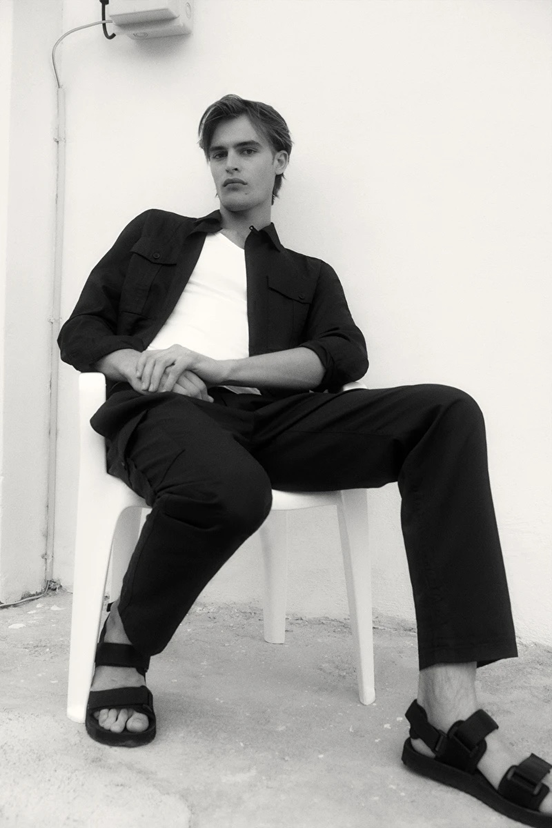 Connecting with COS for summer, Parker Van Noord models a utility camp collar shirt with pants and strap sliders.