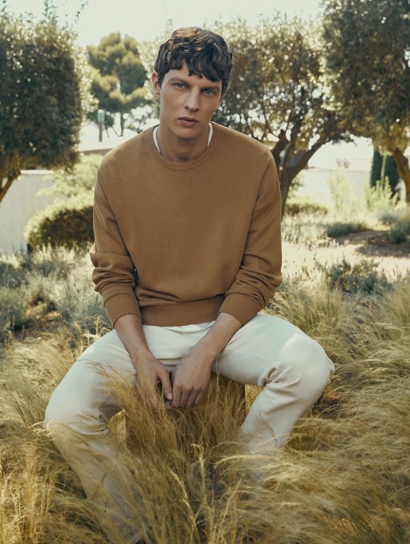 Enjoying the sights of nature, Tim Schuhmacher wears a crewneck sweater with white pants by Massimo Dutti.