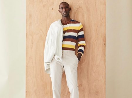 Front and center, Armando Cabral dons a long-sleeve striped pocket tee with a neutral-colored jacket and pants from Todd Snyder.