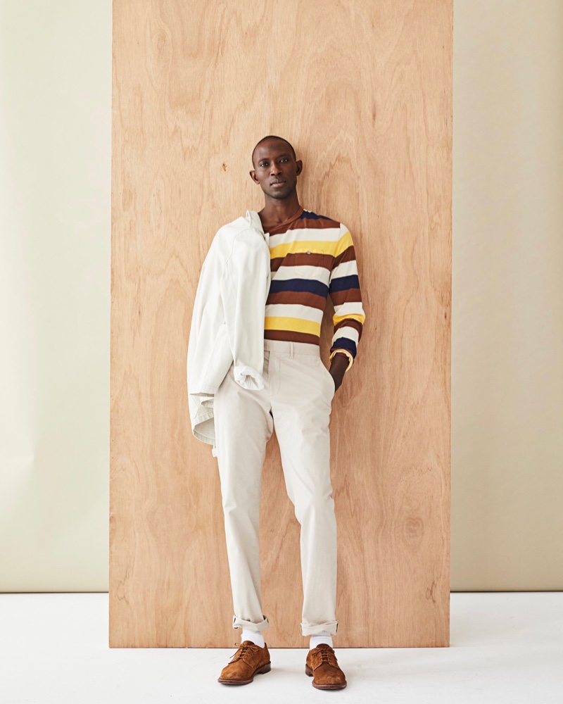 Front and center, Armando Cabral dons a long-sleeve striped pocket tee with a neutral-colored jacket and pants from Todd Snyder.