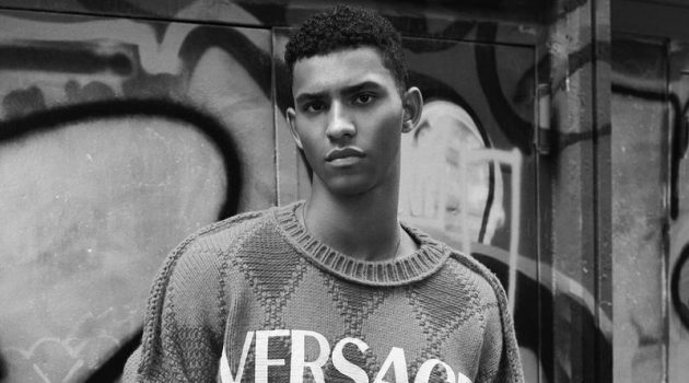 Jan & Noah Celebrate New Versace SoHo Boutique in Pre-Fall Fashions Jan Carlos Diaz sports an argyle Versace sweater as he poses for a photo in SoHo, New York.