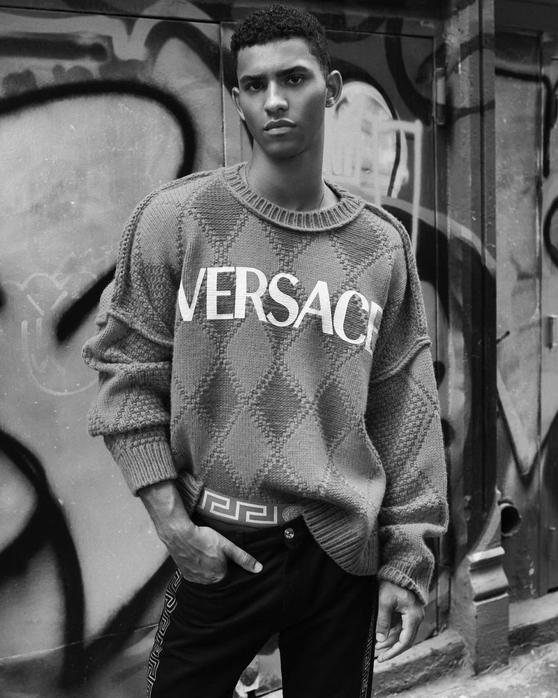 Jan Carlos Diaz sports an argyle Versace sweater as he poses for a photo in SoHo, New York.