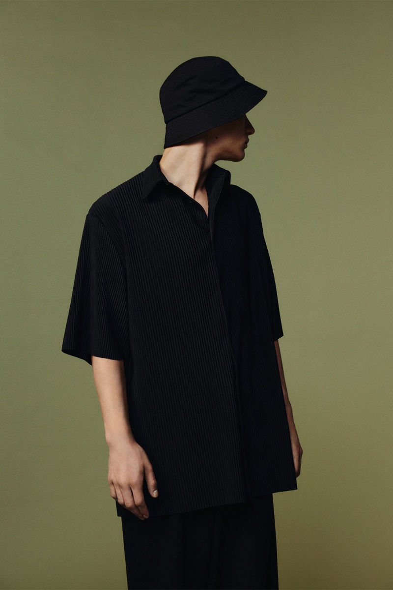Sporting a black bucket hat, Andreas wears a pleated oversized shirt and pants by Zara.