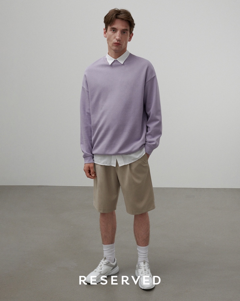 Offering a relaxed spin on preppy style, Anatol Modzelewski embraces the oversized trend in a sweatshirt, collared shirt, and shorts from Reserved.