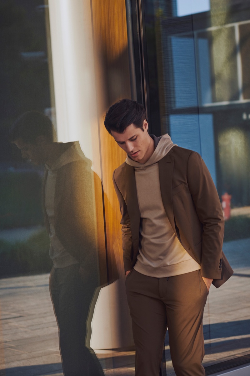 Embracing shades of brown, Emilio Flores wears a suit and hooded pullover from Boggi Milano.