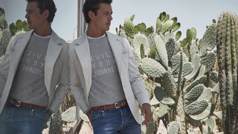 A chic vision, Harry Gozzett models a gray sweater with an unlined jacket and denim jeans from Brunello Cucinelli.