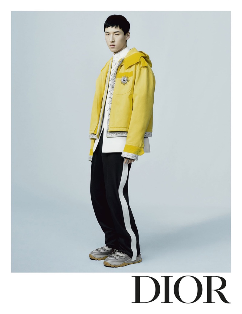 Woosang Kim is front and center for Dior Men's fall-winter 2021 campaign in a yellow hooded jacket with side stripe pants.