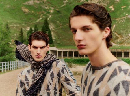 Models Emiliano Marku and Hugo Gillain sport geometric print sweaters from Giorgio Armani.