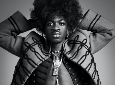 Channeling Jimi Hendrix, Lil Nas X wears a Louis Vuitton jacket with vintage fashions and accessories for VMAN.