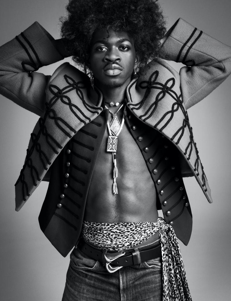 Channeling Jimi Hendrix, Lil Nas X wears a Louis Vuitton jacket with vintage fashions and accessories for VMAN.