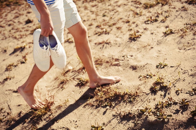 Man Holding Sneakers Walking Ground Barefoot