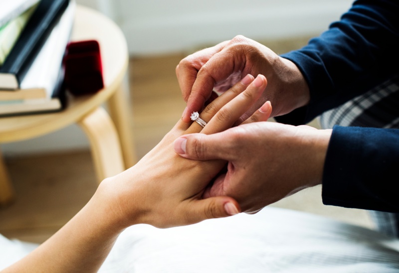 Man Placing Engagement Ring Womans Hand