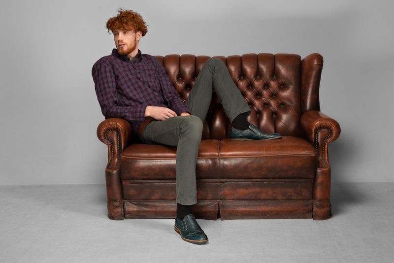Man Sitting on Vintage Leather Couch Man Sitting on Vintage Leather Couch