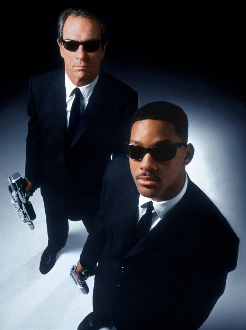 Tommy Lee Jones and Will Smith appear in a promotional image for Men in Black (1997). Nothing quite says secret agent like a uniform black suit and then you add sunglasses for an extra cool!