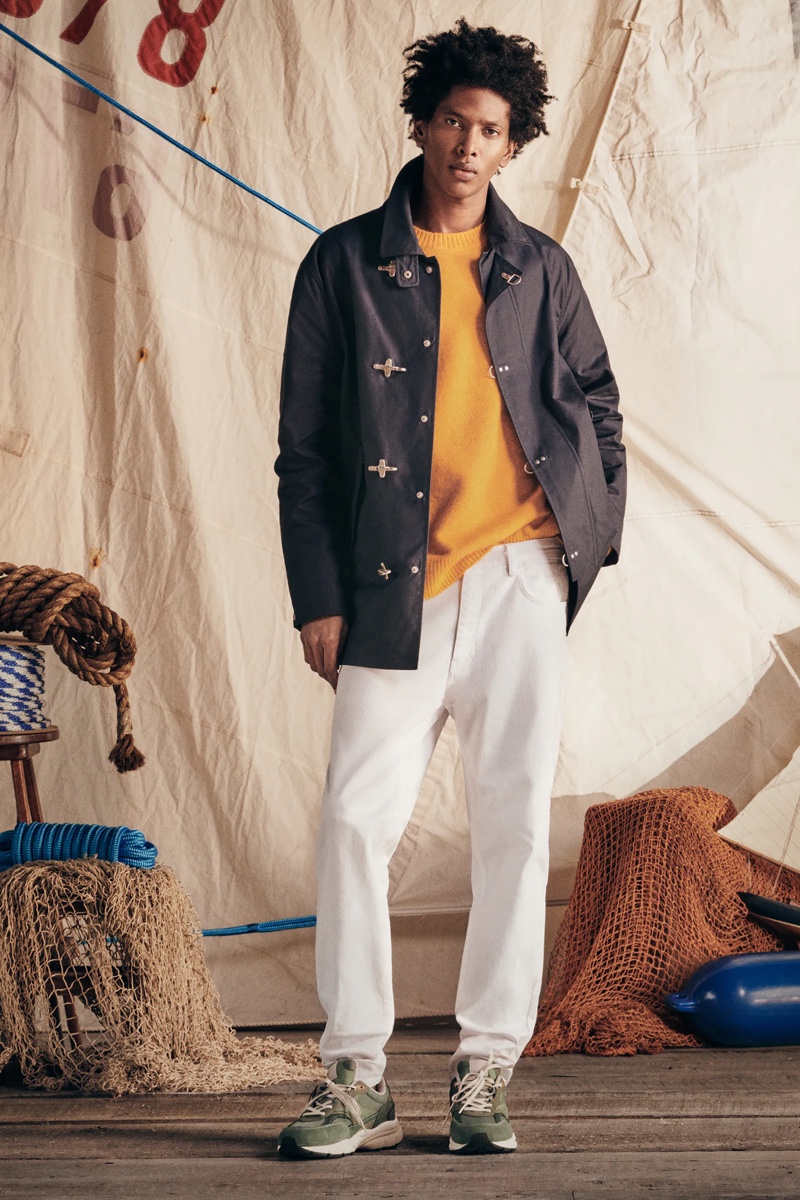 Rafael Mieses models white straight-fit jeans with a sweater and cotton pocket jacket by Zara.