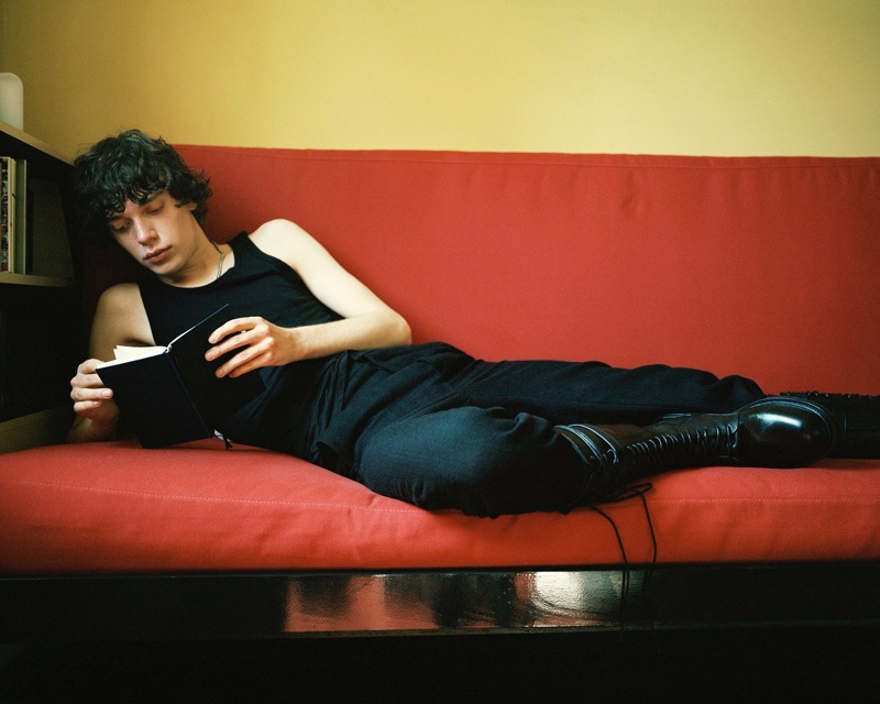Relaxing and reading a book, Nick dons a classic Ann Demeulemeester look in black for the brand's  fall-winter 2021 campaign.