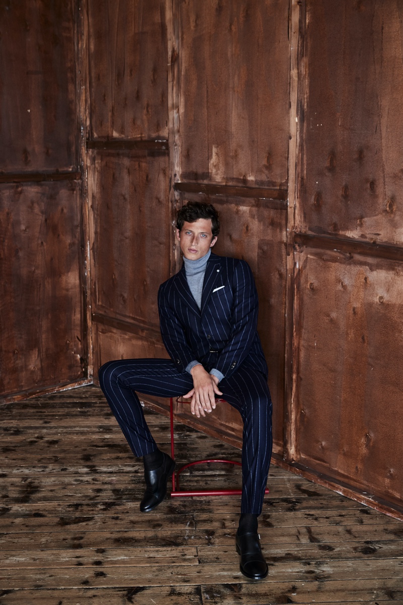 Alexis Maçon-Dauxerre dons a pinstripe suit with a turtleneck sweater from Luigi Bianchi Mantova's fall-winter 2021 collection.