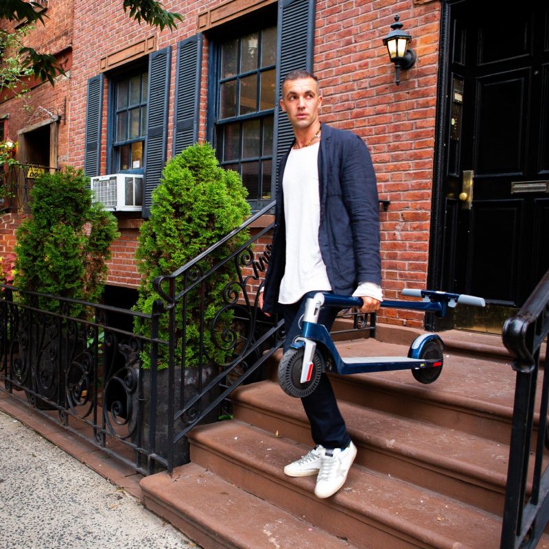 Man Carrying Unagi Electric Scooter